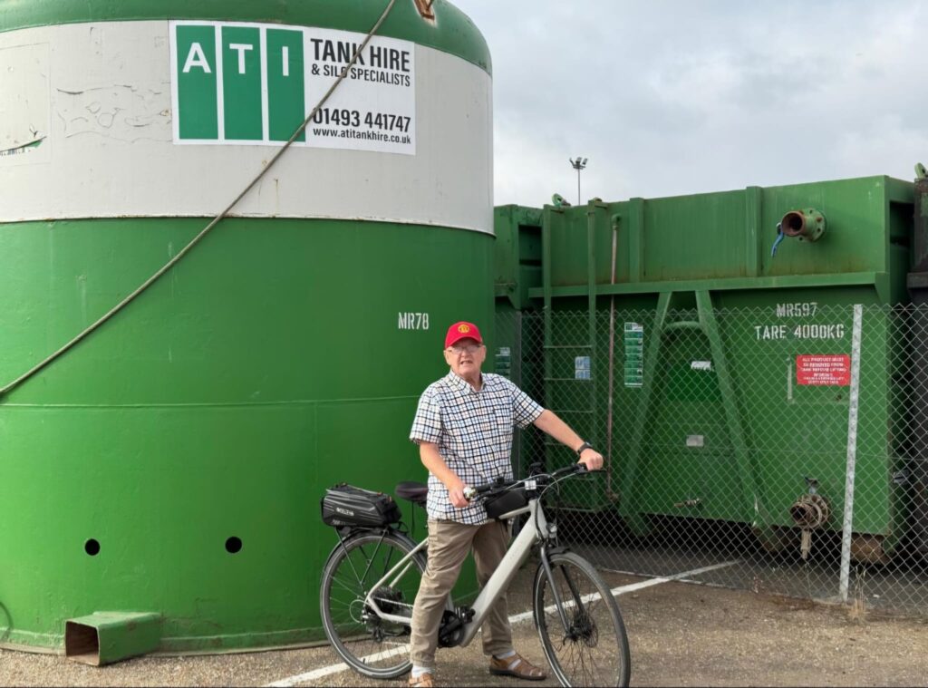 man on bike in front of a tank