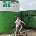 man on bike in front of a tank